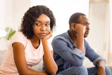 Ayrılma zamanı. Hüsrana uğramış Afrikalı erkek ve kadın evdeki kanepede oturuyor.