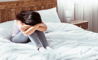 Depresyon Konsepti. Asyalı Kadın, evde yatağında oturan kötü haberleri aldıktan sonra ağlayarak elleriyle yüzünü gömüyor. Boş Boşluk