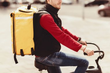 Kurye. Sarı çantalı tanınmayan teslimatçı şehirde bisikletle yemek dağıtıyor. Kesilmiş, Boşluk Boşluğu