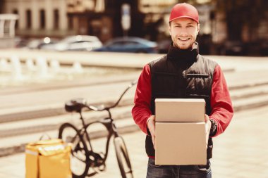 Hızlı Teslimat. Mutlu Kurye Tutma Kutuları, Kameraya Gülümsüyor, Şehirdeki Paketleri Teslim Ediyor. Boş Boşluk