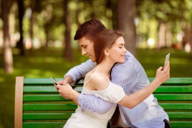 İnternet bağımlılığı. Milenyum çocuğu ve kız arkadaşı şehir parkında sarılıp oynuyorlar.