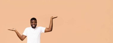 Doğru seçimi yap. Pozitif afrikalı amerikalı adam varyantları karşılaştırarak, onun boş elleriyle ölçekler yapma, turuncu stüdyo arka plan, boş alan