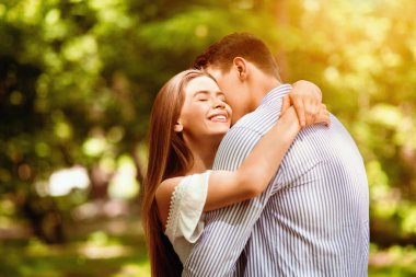 Şefkatli bir çift, kucaklaşıyorlar, yaz parkında birbirlerine bağlanıyorlar. Boşluk alanı