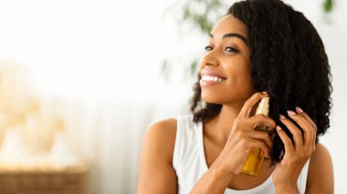 Saç Bakımı. Bölünme için yağ kullanan Mutlu Afro Kadın evde hazırlanırken biter, Kopyalama Boşluğu olan resmi kapat