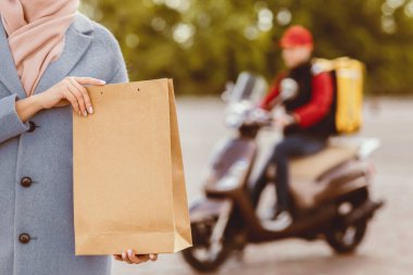 Kurye Servisi. Müşteri Kız Tutucu Dışarıdaki Yiyecek Paketini Teslim Etti. Kırpılmış, Seçici Odaklanma