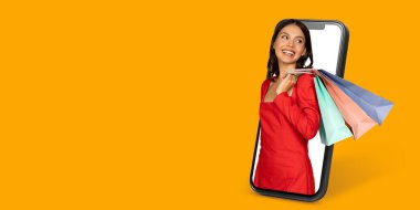 Çevrimiçi alışveriş yapan mutlu bir müşteri renkli alışveriş torbaları sergilerken, e-ticaret alanında modern tüketici deneyimini gösteren ürünlere göz atmak için akıllı telefon kullanır..