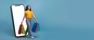 Bir müşteri elinde renkli alışveriş poşetleri tutarken gülümsüyor, büyük bir akıllı telefon ekranından mavi arka plana doğru adım atıyor. Bu çevrimiçi alışveriş ve ticaretin neşesini yakalıyor..
