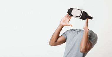 Bir kullanıcı sanal gerçeklik kulaklığı takar ve yeni deneyimlere dalardı. Modern cihaz teknolojideki yenilikleri vurguluyor, sanal etkileşimdeki gelişmeleri gösteriyor.