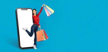 Neşeli bir müşteri büyük bir akıllı telefon ekranından neşeyle çıkarken alışveriş torbalarını tutar. Çevrimiçi alışverişin ve modern ticaretin heyecanını canlı bir ortamda somutlaştırıyor..