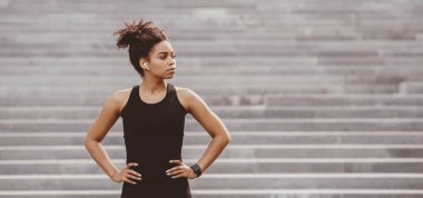 Koşu egzersizleri ve sağlıklı yaşam tarzı. Cidden Afro-Amerikan spor giyim sektöründe gri merdivenlerde spor takip cihazı, panorama, boş alan