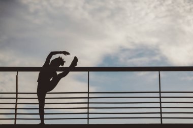 Maratondan önce kaslarımı çalıştırıyorum. İnce kaslı Afrikalı Amerikalı kız silueti stadyumda bacak egzersizi yapıyor.