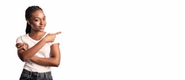 Genç bir bayan, sağ elini göstererek kollarını kavuşturup gülümsüyor. Üzerinde basit bir tişört ve kot şort var. Rahatlamış bir atmosfer izlenimi veriyor..