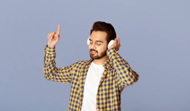 Milenyum Hint müzik aşığı menekşe arka planda, panoramada en sevdiği şarkıları kulaklıkla dinliyor.