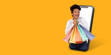 Neşeli bir birey akıllı bir telefonla konuşurken alışveriş torbalarını tutmaktan mutlu olur. Parlak arka plan online alışverişin heyecanını arttırır.