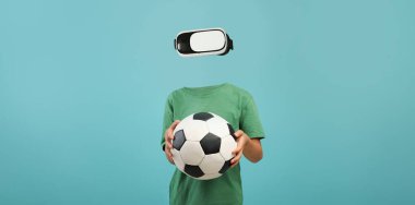 Sanal gerçeklik kulaklığı takan bir insan, elinde futbol topu tutarken derin bir deneyim yaşıyor. Minimalist arka plan cihaza ve etkinliğe odaklanmayı arttırır..