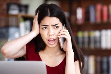 Oh hayır. Asyalı bir kadının bilgisayarla ilgili sorunları var. Kafe 'de çalışırken cep telefonuyla müşteri desteği ile konuşuyor.