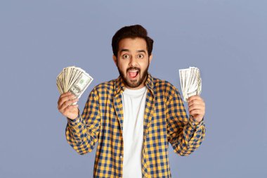 Elleri para dolu şoke olmuş Hintli adam leylak arka planda vow diye bağırıyor.