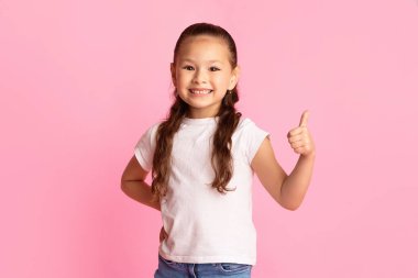 Her şey harika. Tatlı Japon çocuğun portresi Pastel Pembe Stüdyo duvarına başparmak işareti yapıyor, fotokopi odası.
