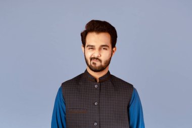 Mor arka planda şüphe gösteren yakışıklı Hintli adam.