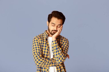 Leylak arkaplanı üzerinde çok çalıştıktan sonra uyuyan yorgun Hintli adam.