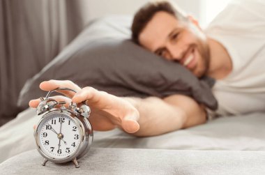 İyi sabahlar. İyi Uyuyan Adam 'ın alarmını kapatması, uyandığında evde yatağında yatması. Sığ Derinlik, Seçici Odaklanma