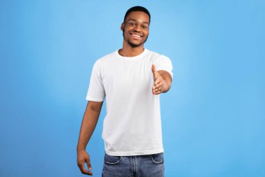 Siyah adam el sıkışmak için elini uzatıyor. Mavi Stüdyo 'nun arka planında gülümsüyor. Tanıştığımıza memnun oldum.