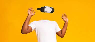 Sanal gerçeklik aktivitesine katılan bir kişi görünür bir kafası veya yüzü olmadan tasvir edilir. Parlak sarı arka plan, teknolojinin özünü yakalamak için kullandıkları modern cihazın altını çiziyor..