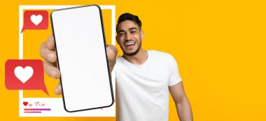 Neşeli bir nüfuzlu kişi, canlı sarı bir arkaplan karşısında boş ekranlı akıllı bir telefonu kaldırır. Etrafı, kalpleri ve sevdikleri şeyleri içeren görsel sohbet baloncuklarıyla çevrilidir..