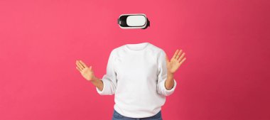 Sanal gerçeklik gözlüğü takan bir insan ellerini kaldırıp dijital bir deneyime dalmıştır. Parlak pembe arkaplan kulaklık ve kullanıcı etkileşimine odaklanmayı güçlendirir.