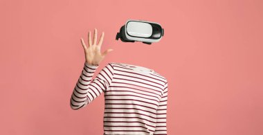 Bir kullanıcı, modern teknolojiyi gösteren bir kulaklıkla sanal gerçeklikle bağlantı kurar. Bireyin, genişletilmiş ortamların engin deneyimini vurgulayan görünür bir kafası veya yüzü yoktur..