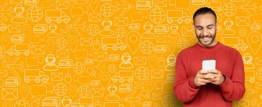 İnternetten alışveriş yapmak için akıllı telefonunu kullanan bir adam gülümsüyor. Uygulamayla meşgul görünüyor, ilgili simgelerle dolu renkli ve canlı bir arkaplana karşı dağıtım seçeneklerini araştırıyor..