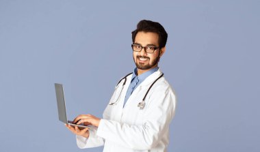 Siber tıp konsepti. Mutlu Hintli doktor dizüstü bilgisayarda hastayla konuşuyor, menekşe arkaplan. Panorama