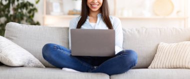 Serbest Kavram. Evde dizüstü bilgisayarda çalışan gülümseyen Koreli kız oturma odasında rahat bir koltukta oturuyor, boşluğu kopyalıyor.