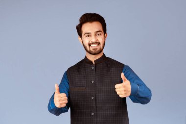 Mutlu Hintli adam olumlu bir jest yapıyor, leylak arkaplan üzerinde pozitiflik gösteriyor. Panorama