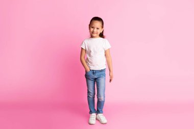 Sıradan bir model. Kameraya el ele poz veren yakışıklı Asyalı çocuğun tam boy portresi. Pembe stüdyo duvarı, fotokopi odası.