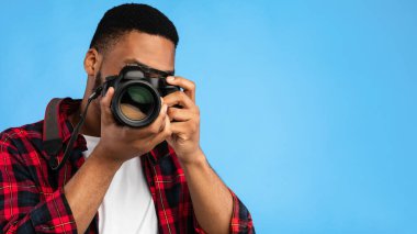 Fotoğrafçılık. Profesyonel Fotoğrafçı Modern Kamera Tutan Fotoğraf Çeken Stüdyoda Mavi Arkaplan Üzerinde Duran.