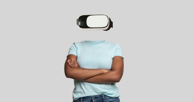 Sanal gerçeklik gözlüğü takan bir insan kollarını tarafsız bir arkaplanda kavuşturarak güvenle ayakta durur. Kafanın yokluğu, cihazlara ve modern teknolojiye odaklanmayı vurguluyor..