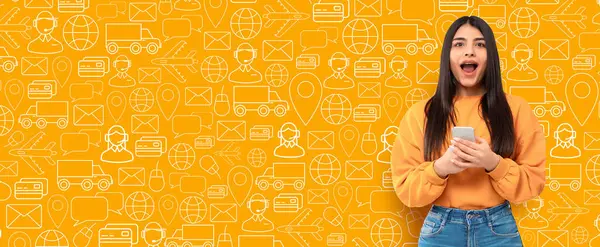 Genç bir müşteri internetten alışveriş yapmak için heyecanlı bir şekilde akıllı telefon kullanıyor. Renkli arkaplanda e-ticaret faaliyetlerini ima eden teslimat simgeleri ve alışveriş sembolleri yer alıyor.