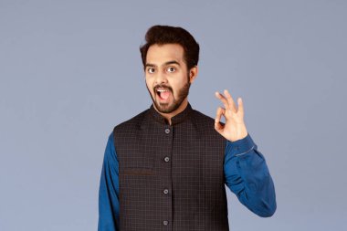 Pozitif ifade etmek. Mutlu Hintli adam leylak arkaplan ve panorama üzerinde iyi bir hareket gösteriyor.