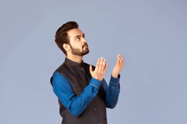 Hintli adam Tanrı 'ya dua ediyor, yardım ya da bağışlanma diliyor, leylak arka planda, panorama