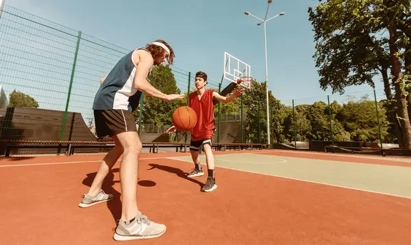 Açık alanda yarışmaya hazırlanan iki profesyonel basketbolcunun panoramik görünümü, kopyalama alanı