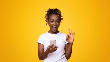 Yeni mobil uygulamayı sevdim. Akıllı telefonlu duygusal siyah kız tamam, sarı arka plan, serbest alan