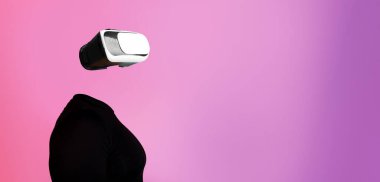 Bir insan gelişmiş sanal gerçeklik teknolojisiyle bir kulaklık kullanarak meşgul olur. Başsız görünen figür, modern bir ortamda canlı bir arkaplan içinde aygıtı vurguluyor.