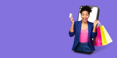 Bir kadın, büyük bir akıllı telefon ekranından çıkan alışveriş çantaları ve bir kredi kartı ile neşe içinde bekliyor. Çevrimiçi alışverişi seviyor, coşkulu bir ortamda heyecan gösteriyor..