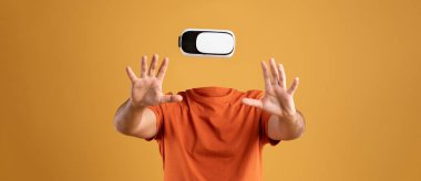 Bir insan sanal gerçeklik kulaklığıyla, kafası görünmezken etkileşime girer. Arkaplanda canlı bir turuncu renk var, büyüleyici teknolojiyi ve modern aktiviteyi vurguluyor..