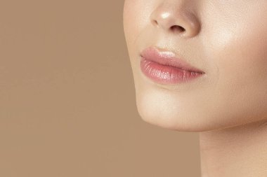 Saf tenli, uzun ipeksi saçlı, kahverengi stüdyo arka planındaki kameraya bakan güzel bir genç hanımın portresi. Kopya alanı. Kozmetik tedaviler ve sağlık konsepti