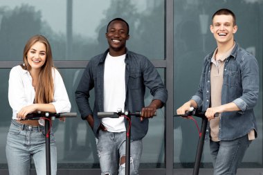 En iyi arkadaşlar. Elektrikli scooterlarla ayakta duran ve kameraya poz veren çeşitli çetelerin portresi