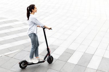 Aktif Boş Zaman. Neşeli kız öğrencilerin stand-up motosikletlerini tuğla yolda sürerken, reklam ve metin için kopyalama alanı