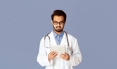 Çevrimiçi tıp konsepti. Hintli doktor web 'deki hastayla iletişim kurmak için tablet bilgisayar kullanıyor, menekşe arkaplan. Panorama