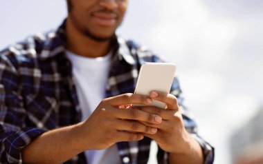 Online sohbet. Kendine güvenen Afrikalı Amerikalının cep telefonu ve mesajlaşması.